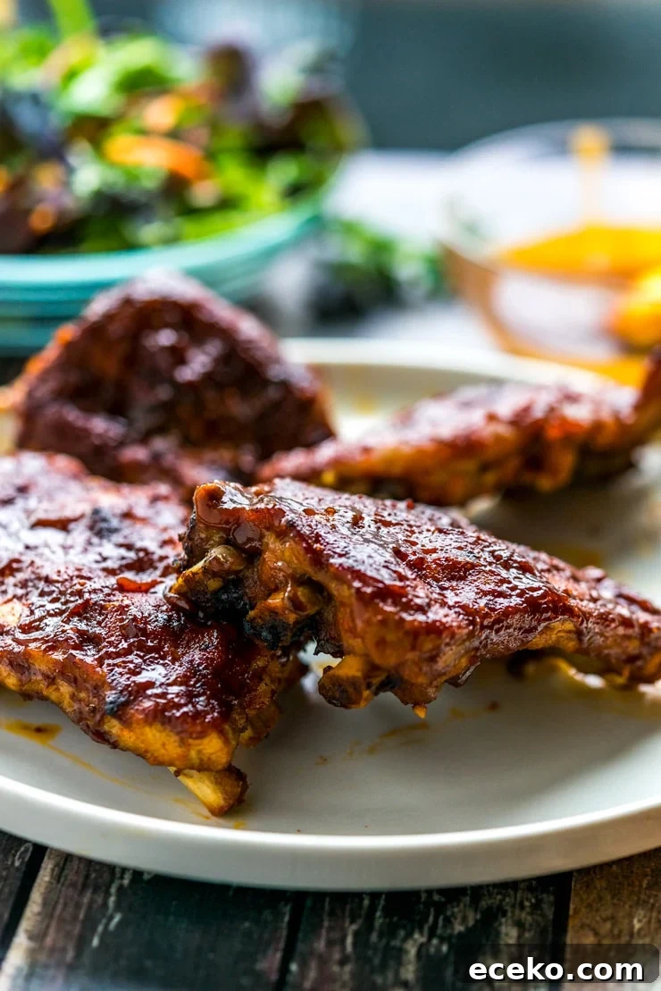 BBQ ribs made in the Instant Pot on a white plate with salad