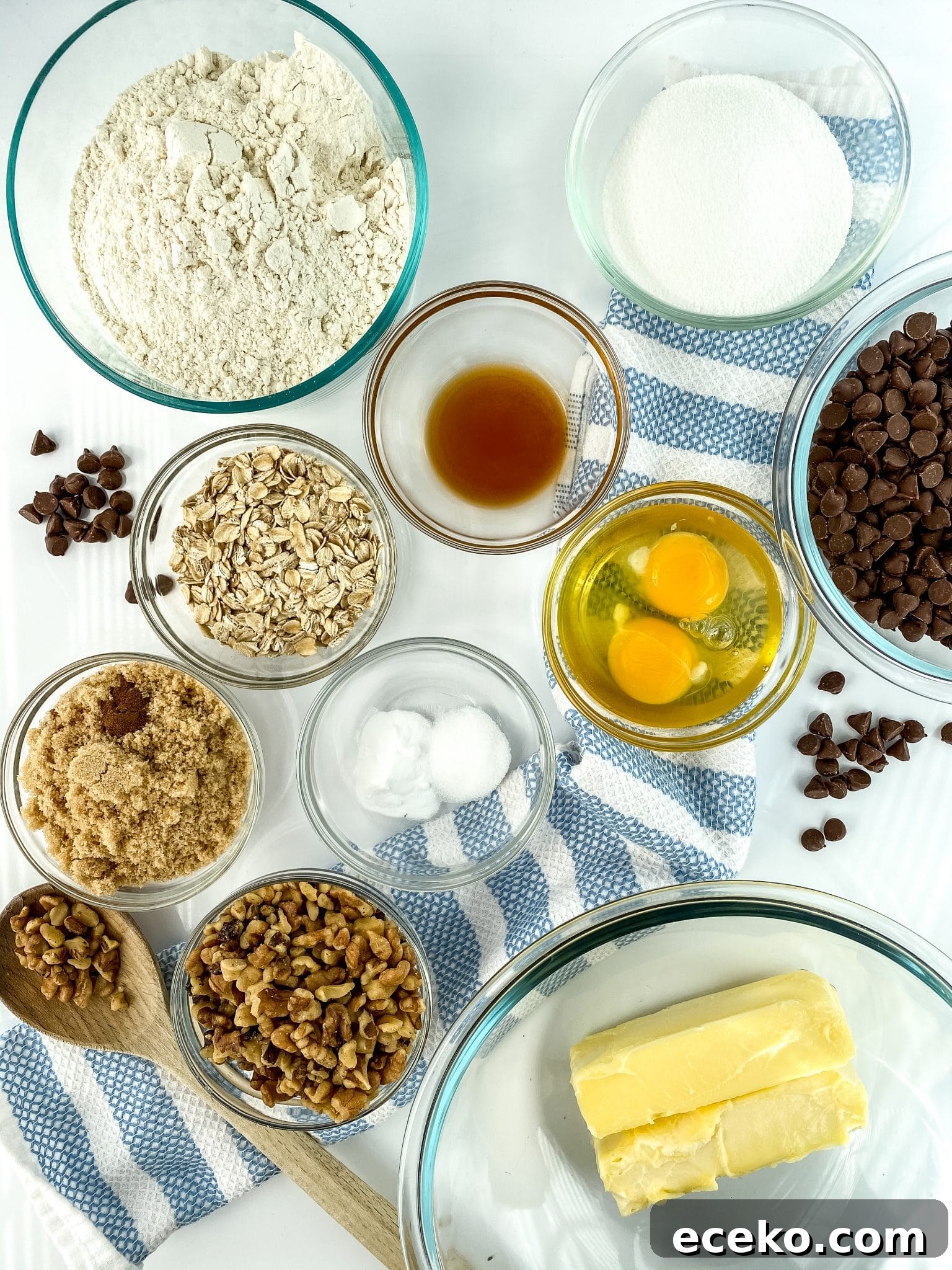 Ingredient shown for recipe: flour, sugar, vanilla, eggs, oats, chocolate chips, butter, walnuts, salt, brown sugar, eggs.
