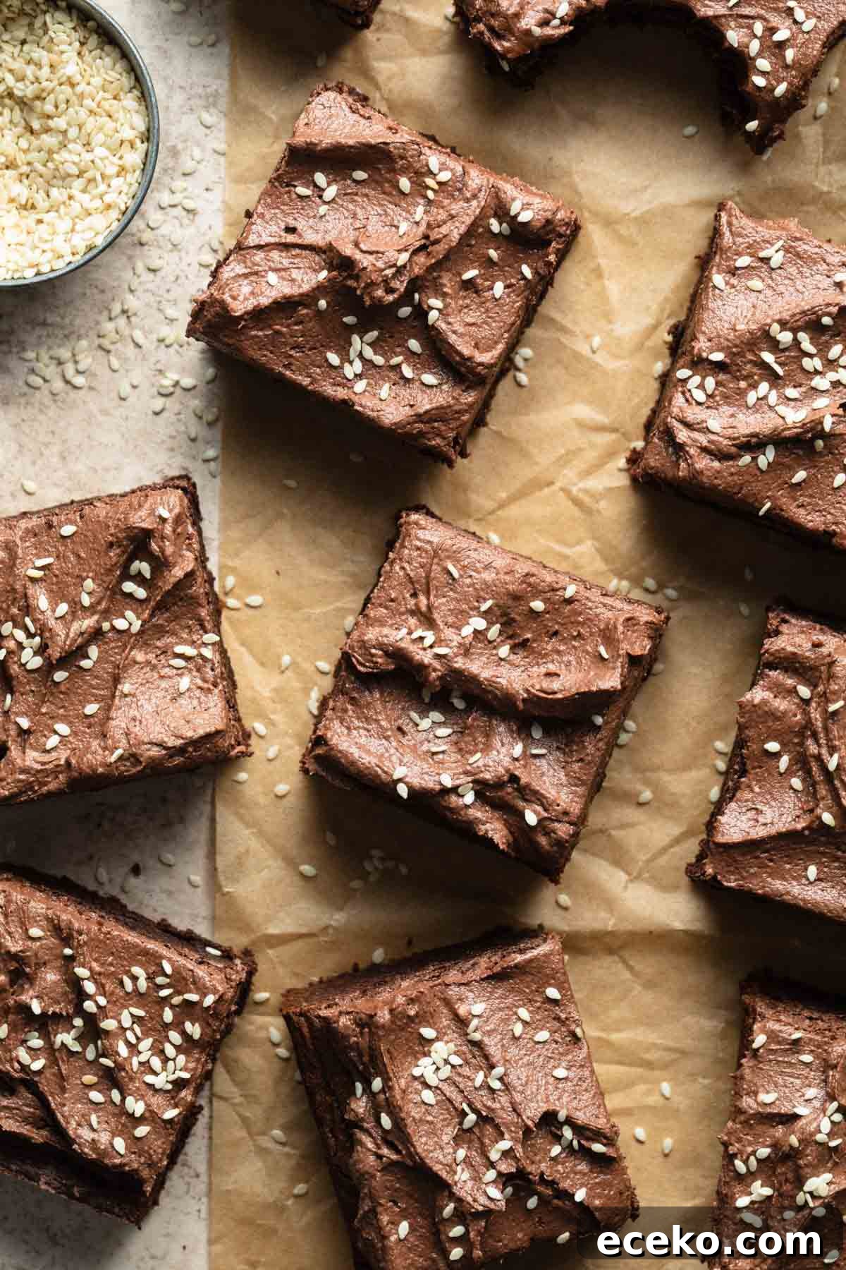 Frosted brownies on a sheet of parchment paper.