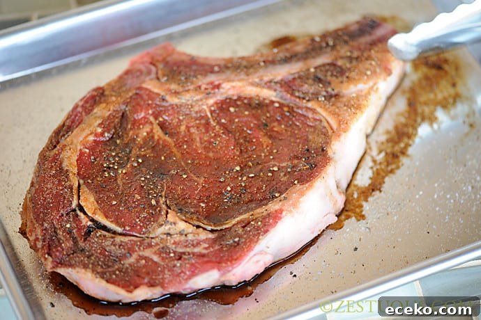 rib-eye steak marinating on sheet pan