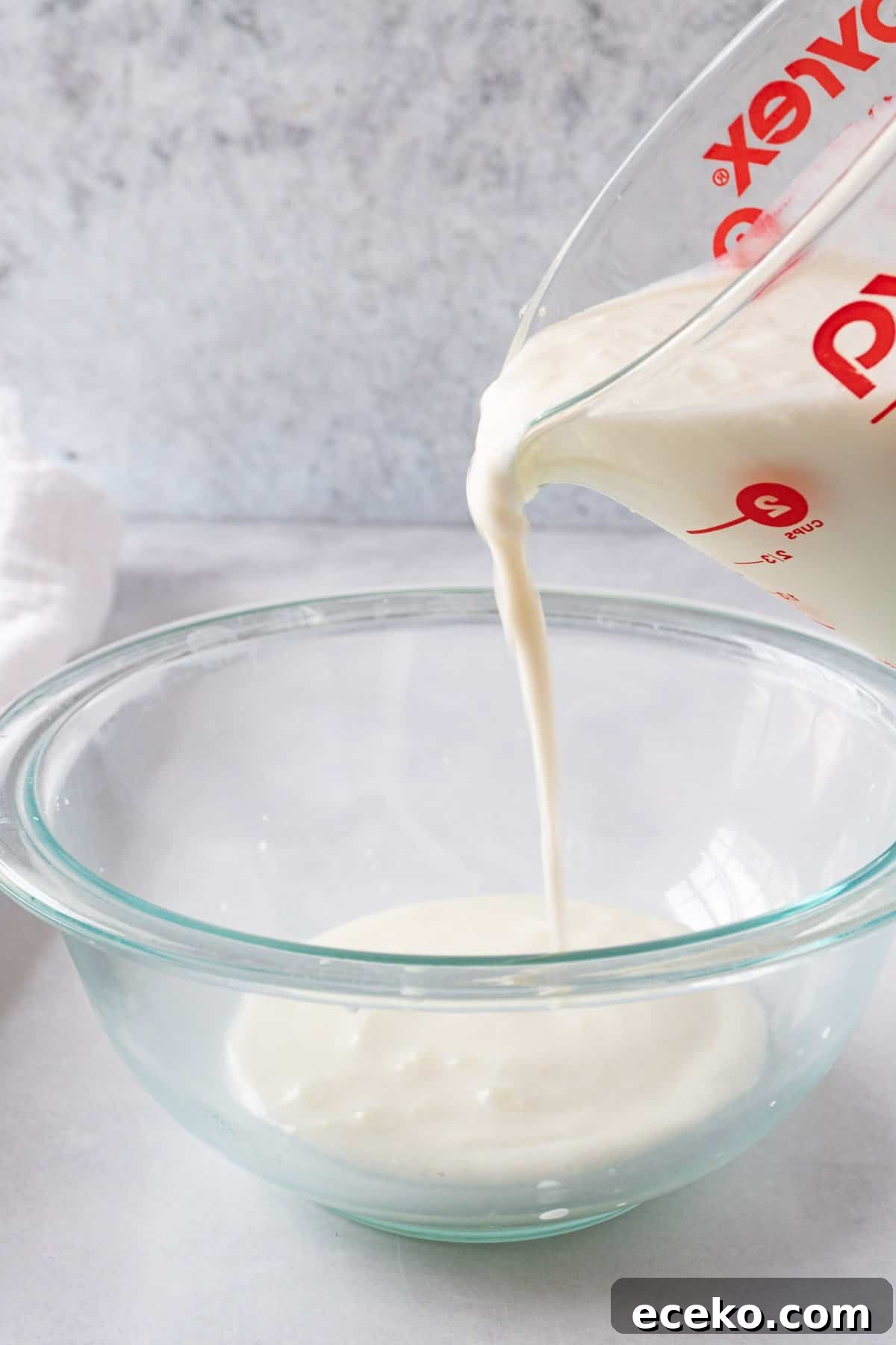 pouring good buttermilk into a  glass bowl.