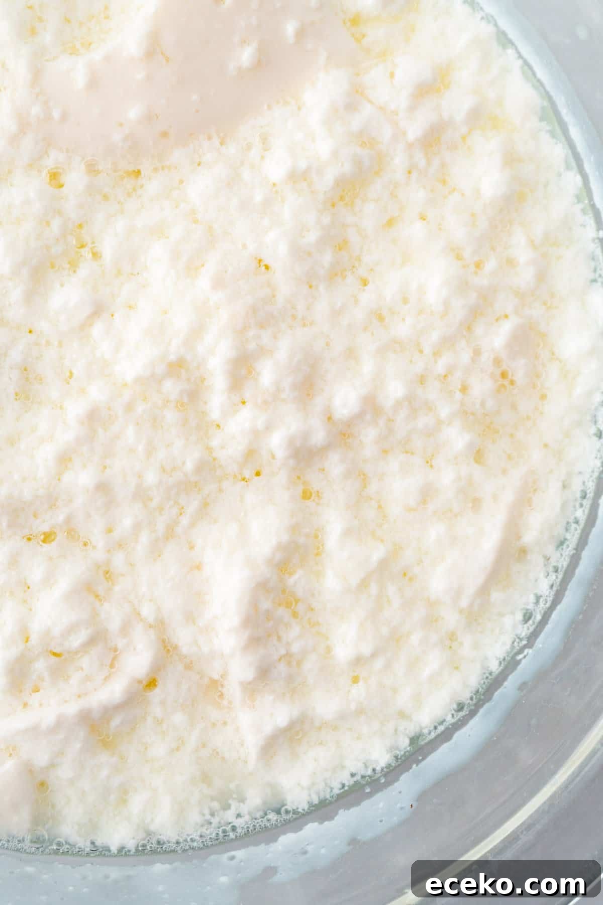 bad curdled buttermilk showing large lumps in glass bowl.