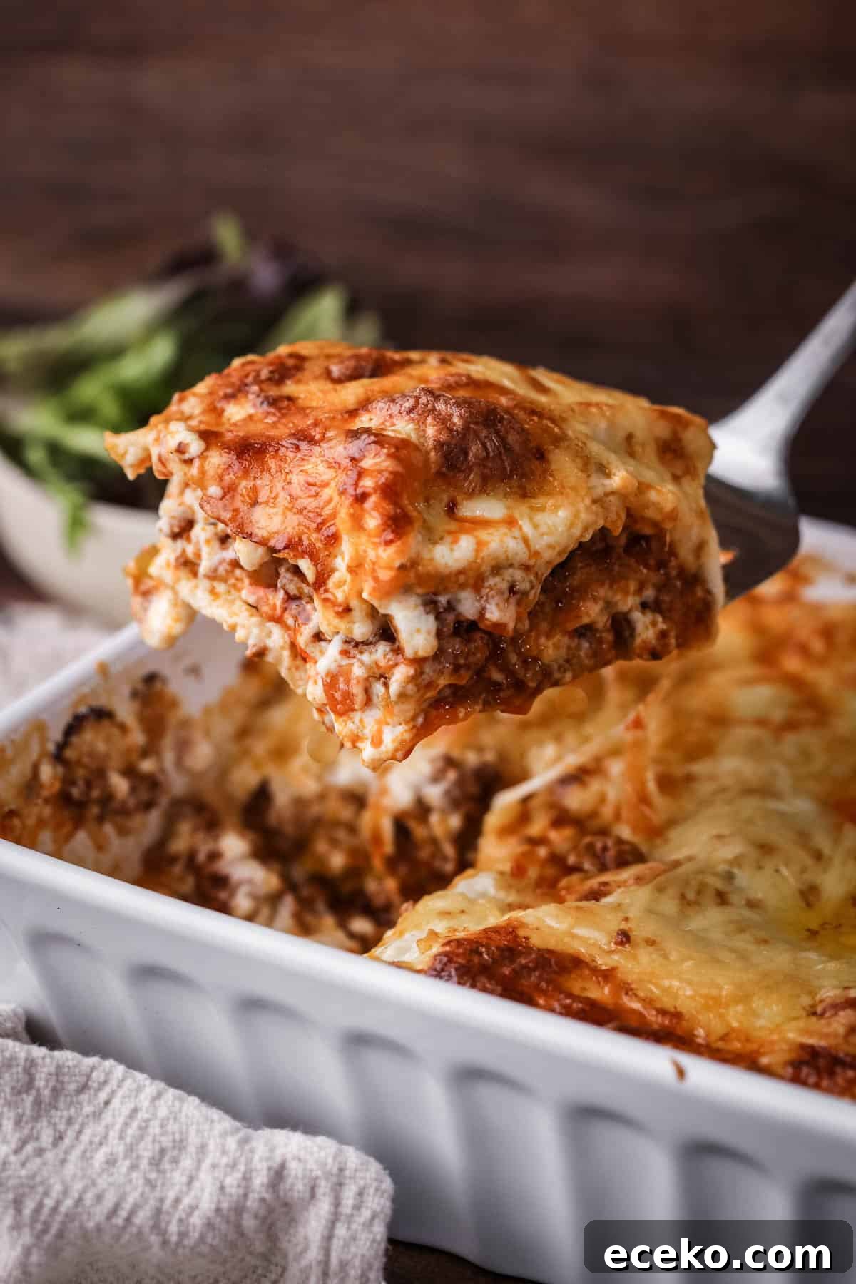 Gluten-Free Lasagna Recipe: Layered Comfort Without Wheat 2 Slice of lasagne lifted out of baking dish, showing cheesy meaty middle.