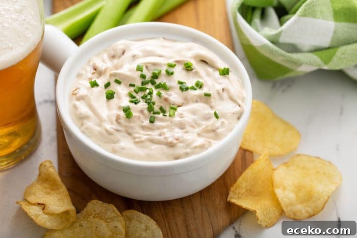 Creamy Homemade French Onion Dip Recipe for Parties 9 Bowl of french onion dip on a wooden board surrounded by potato chips