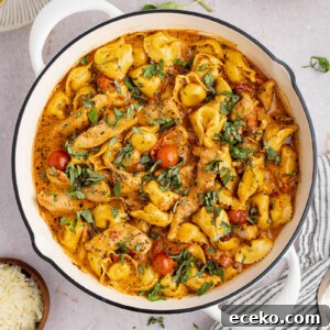 Creamy Chicken Tortellini Recipe with Garlic Parmesan Sauce 6 creamy chicken tortellini in a pan before serving. Fresh basil is garnished on top.