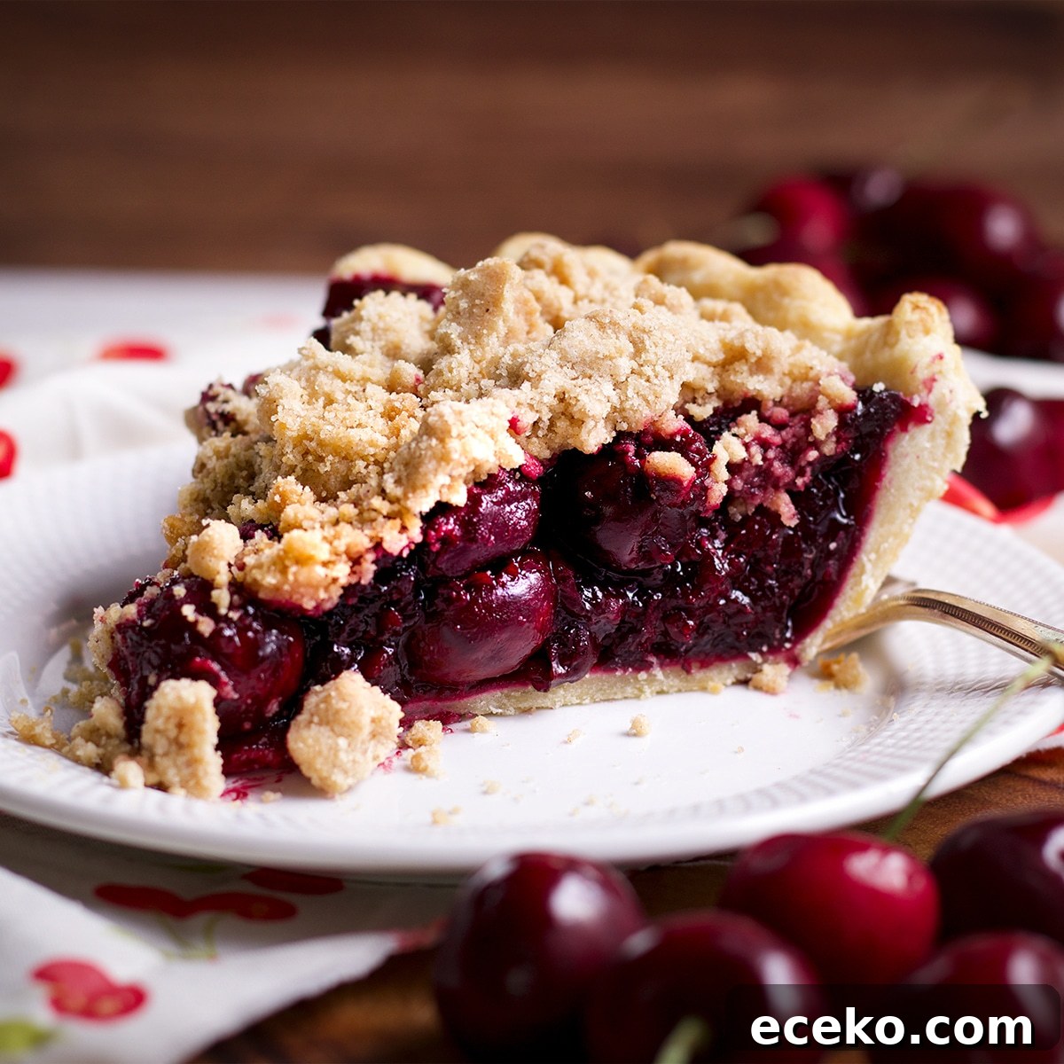 A slice of cherry crumb pie on a plate.
