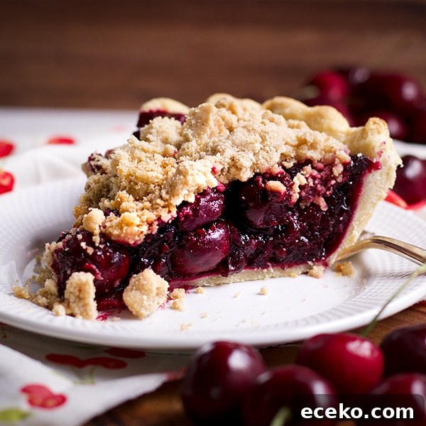 A slice of Cherry Crumb Pie on a plate, ready to eat.