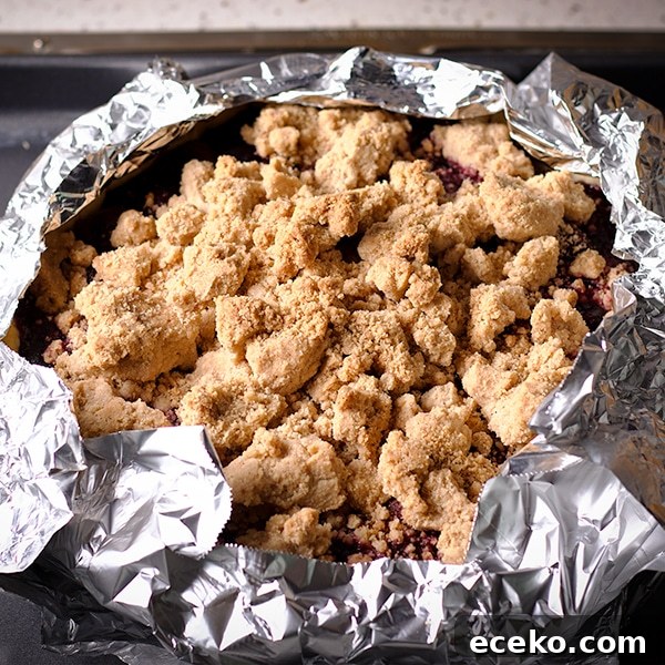 Covering the edges of the crust with foil before baking Cherry Crumb Pie.