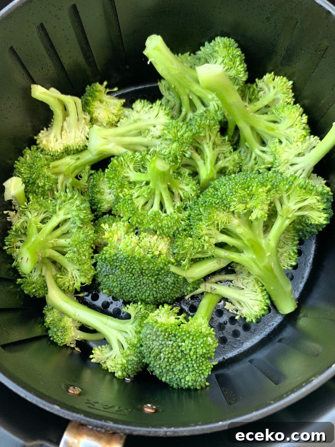 raw and cut broccoli in an air fryer