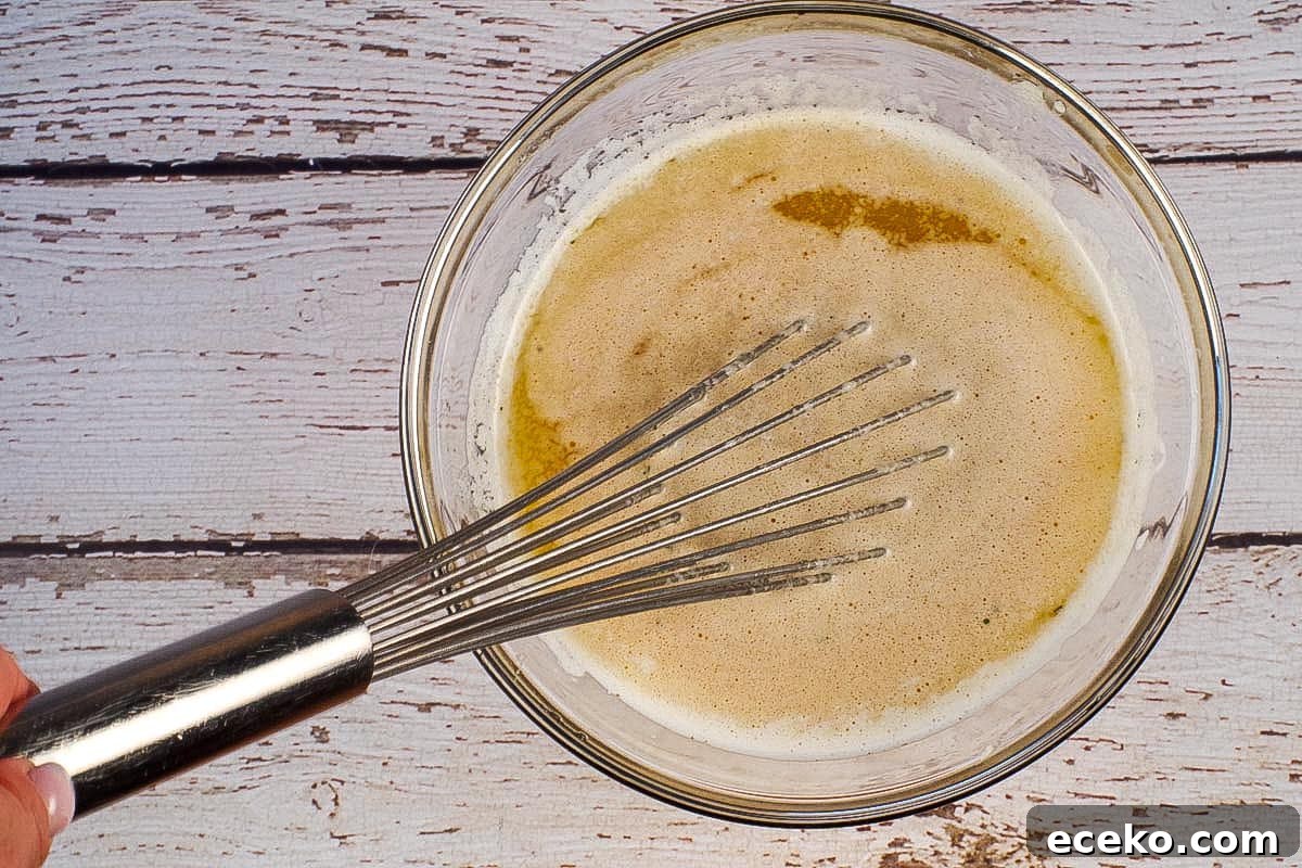 Ranch and Worcestershire Sauce whisked into butter in glass bowl with metal whisk.