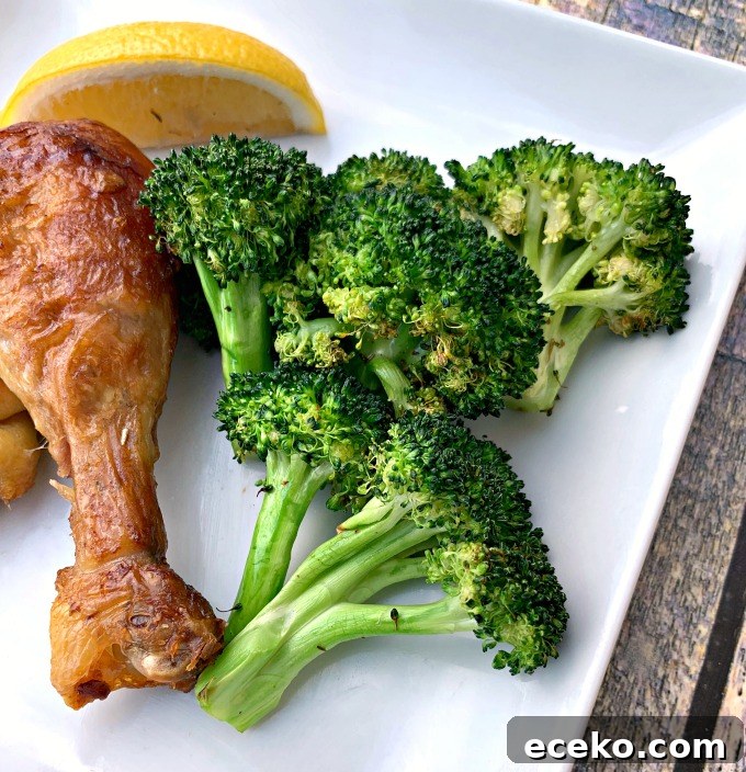 roasted air fryer broccoli with chicken on a white plate