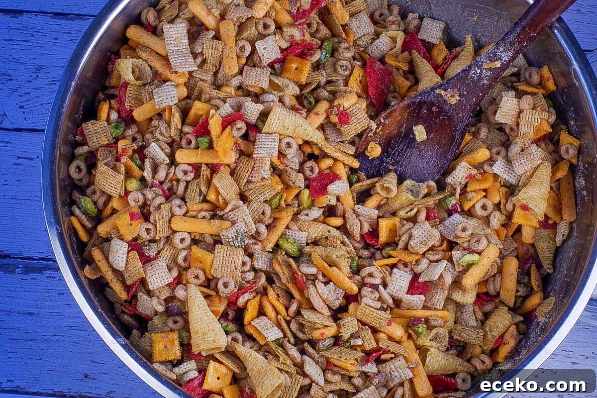 Butter mixture poured into cereal mixture and stirred, in large stainless steel bowl, with wooden spoon.