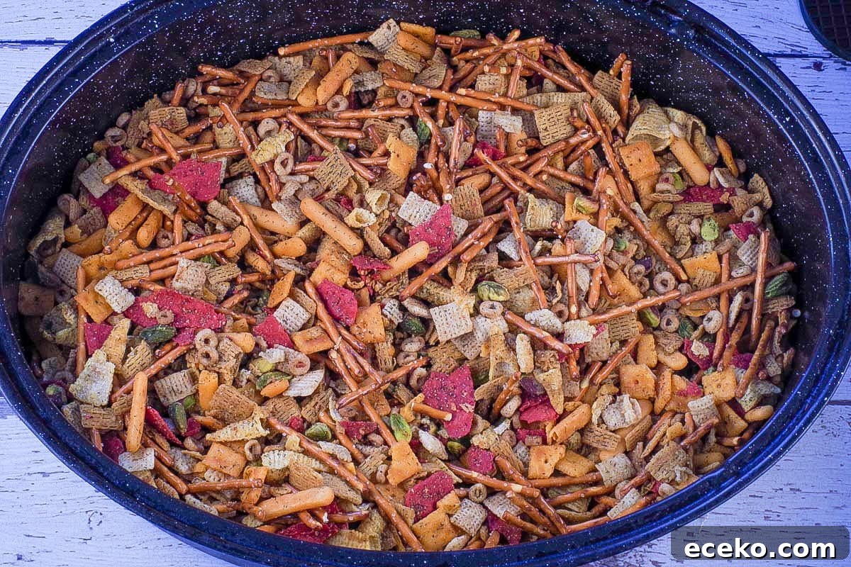 Baked snack mix in large oval roasting pan.