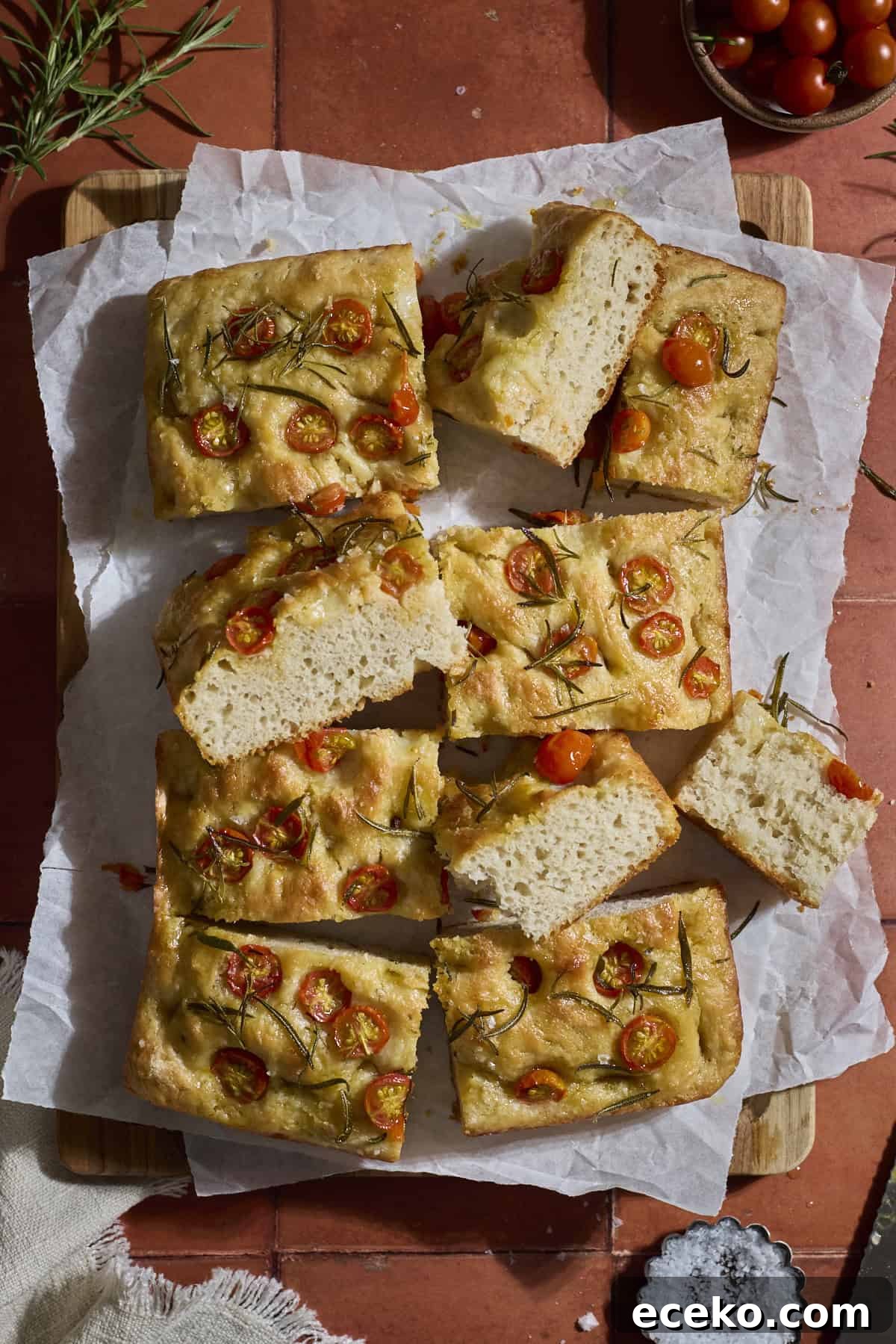 Sliced focaccia on white parchment paper.