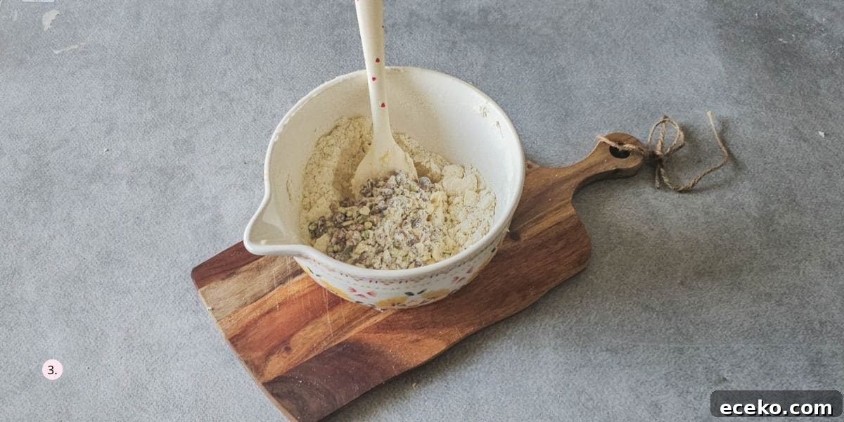 adding cranberries and pistachios to the cookie dough