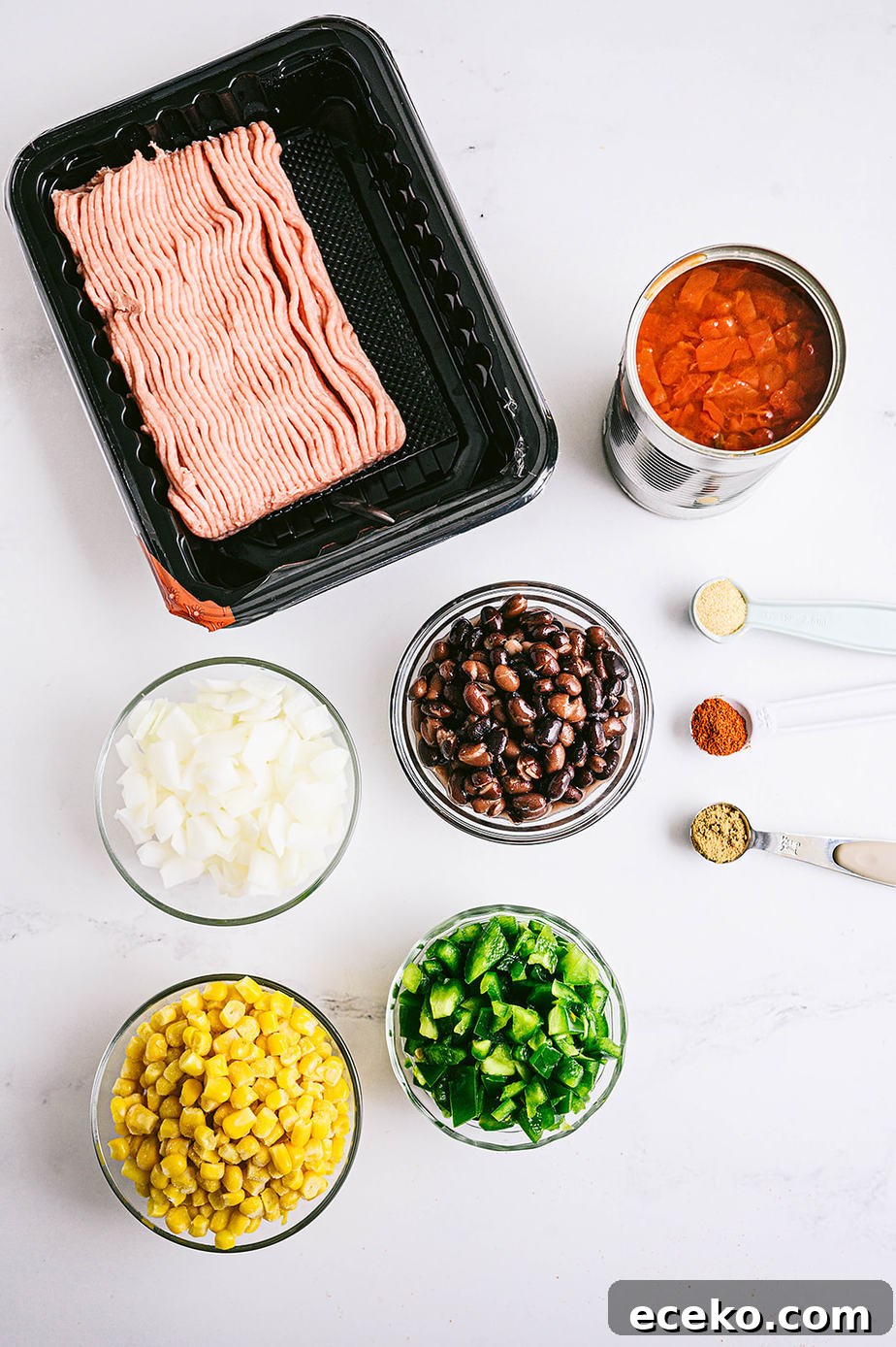 One-Skillet Taco Skallowder: Quick Mexican-Style Skillet Dinner 4 Overhead shot of ingredients for taco skillet: raw turkey, canned tomatoes, beans, corn, onions and bell peppers