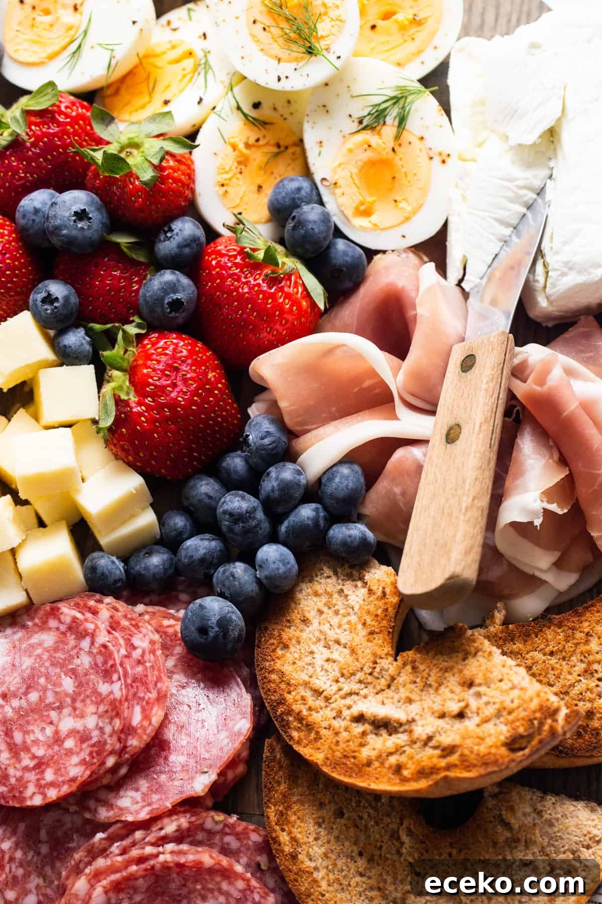 A plate with a variety of meats, cheeses, and fruit.