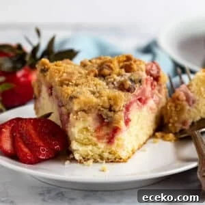 Strawberry Shortcake Crumb Cake Recipe — Moist Summer Dessert 15 Strawberry Cake on a plate with a bite taken out revealing the inside of the cake.