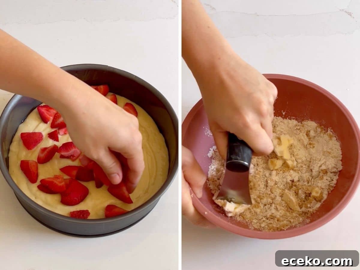 Strawberry Shortcake Crumb Cake Recipe — Moist Summer Dessert 7 Batter in the cake pan and then strawberries added on top. Then a hand cutting together the crumb topping.