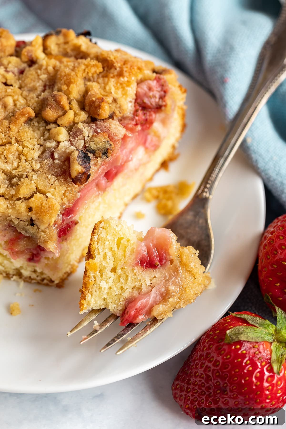 Strawberry Shortcake Crumb Cake Recipe — Moist Summer Dessert 9 A bite of strawberry cake on a fork.