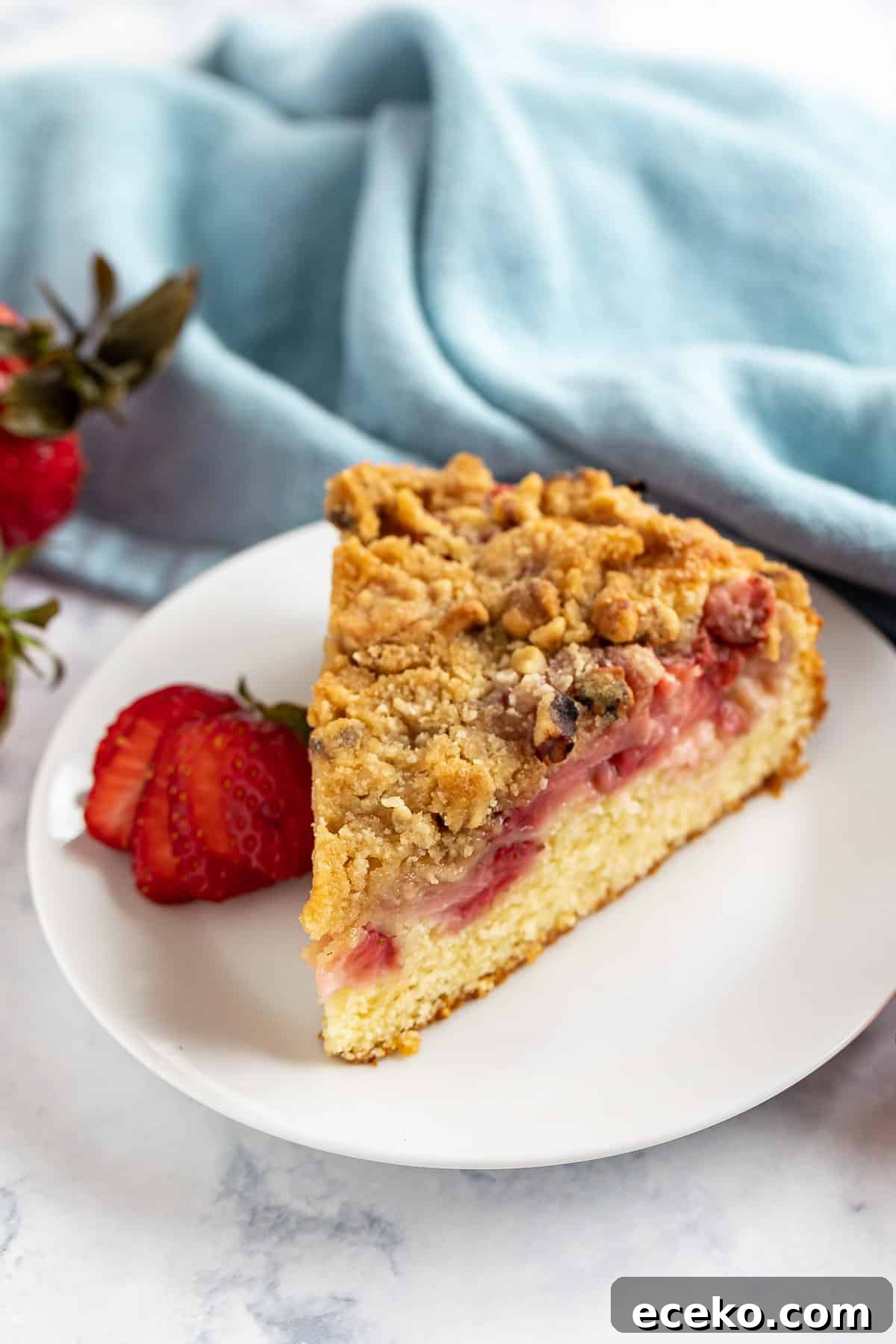 Strawberry Shortcake Crumb Cake Recipe — Moist Summer Dessert 10 A slice of strawberry coffee cake on a white plate.