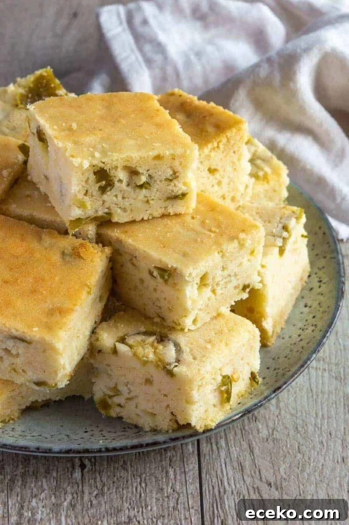 Spicy Vegan Jalapeño Cornbread Recipe 2 A plate of pale gold cornbread speckled with diced jalapeños