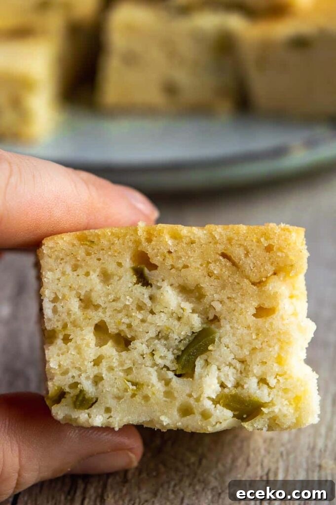 Spicy Vegan Jalapeño Cornbread Recipe 3 a square of cornbread being held in front of a plate of more