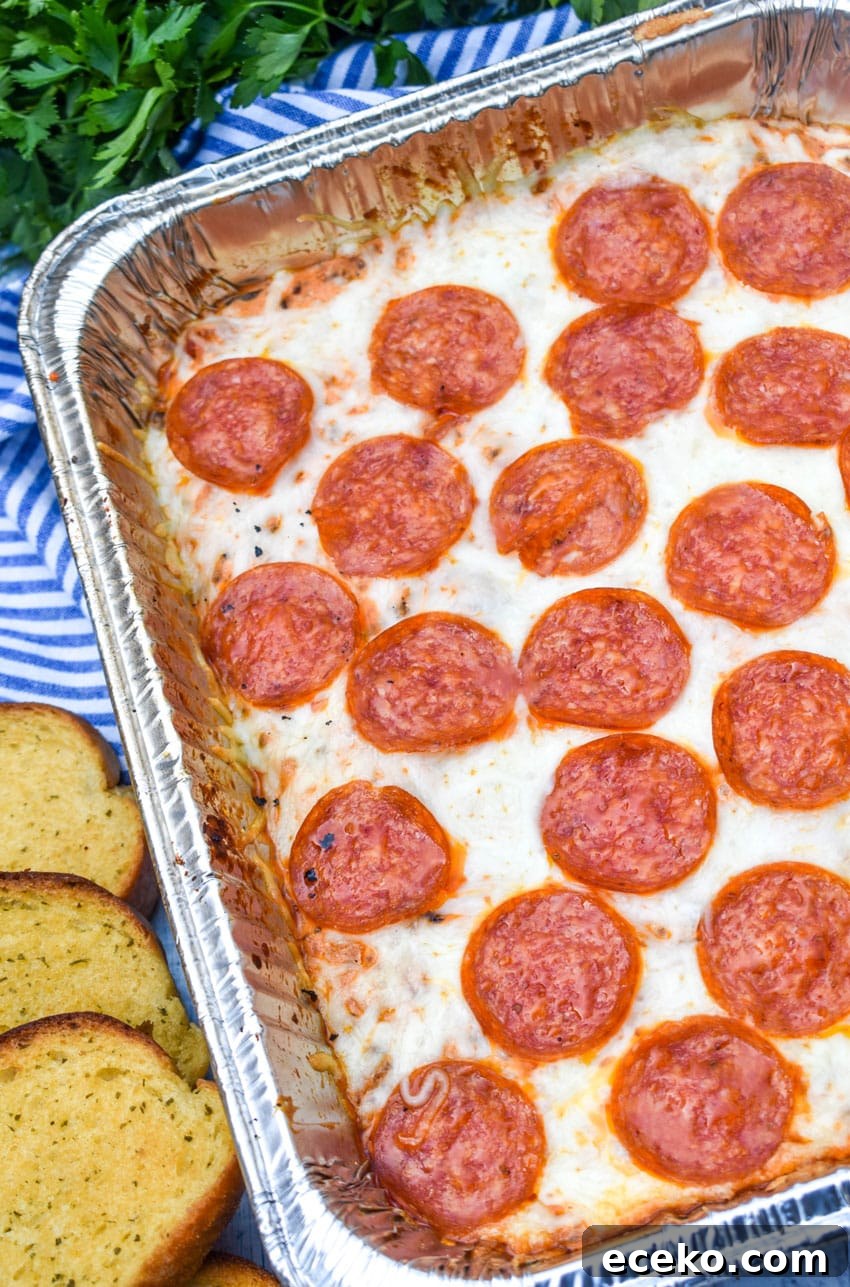 smoked pepperoni pizza dip in an aluminum tray