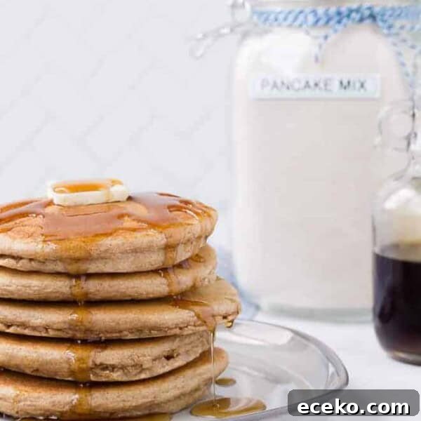 Image of a stack of pancakes with homemade pancake mix in the background.