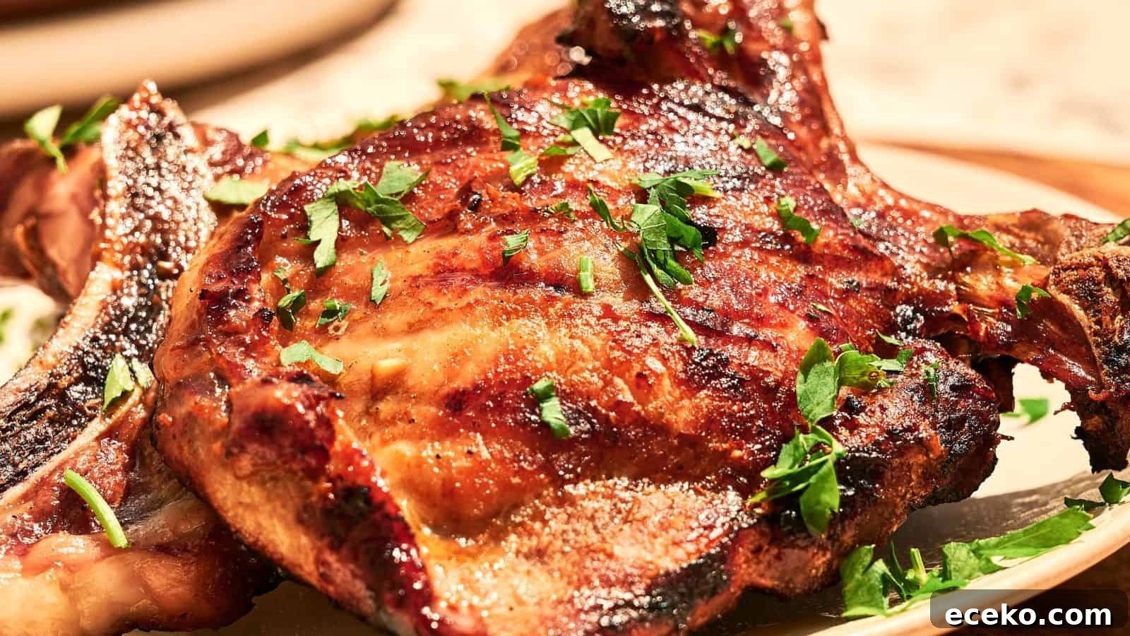 A grilled pork chop garnished with chopped parsley is served on a plate.