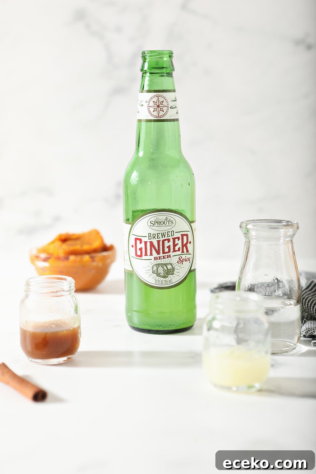 Ginger beer, vodka, pumpkin spice syrup and lime juice on marble before the cocktail is mixed