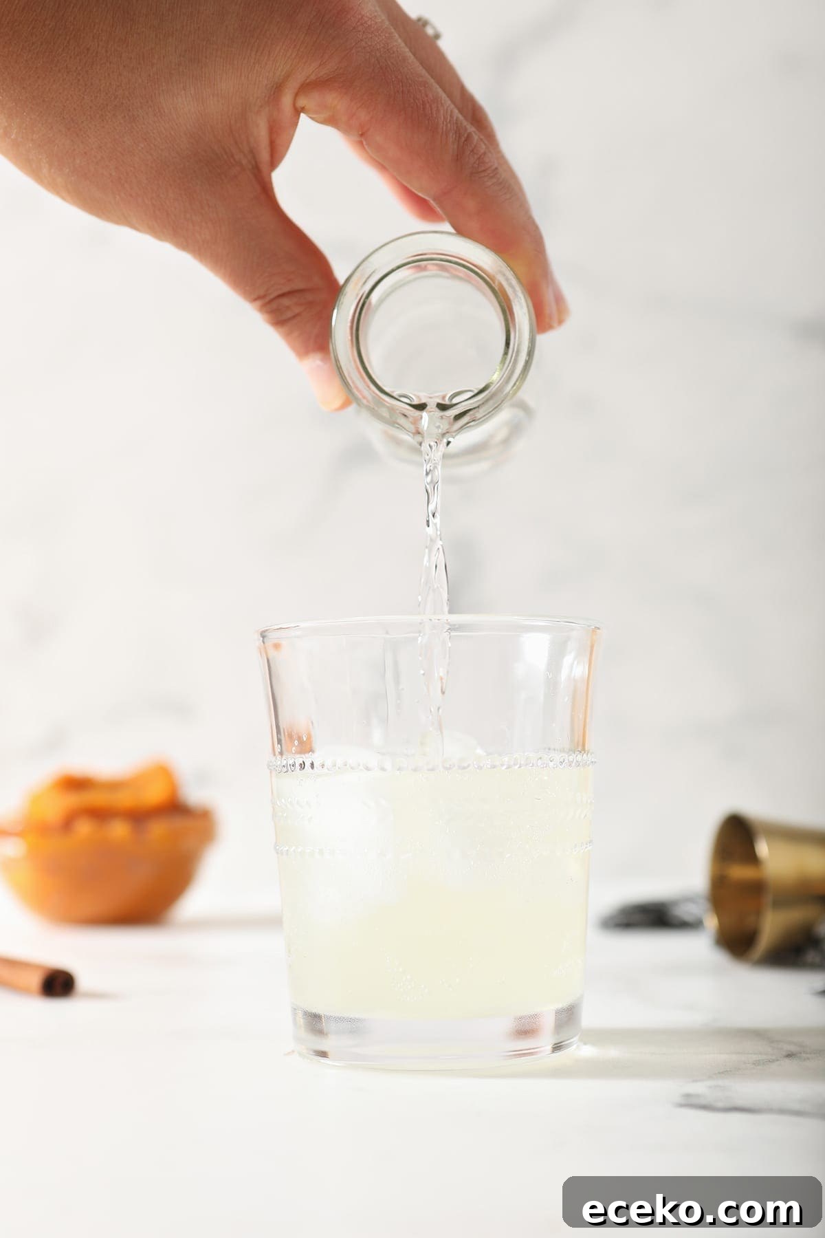 Vodka is poured into a glass of ginger beer