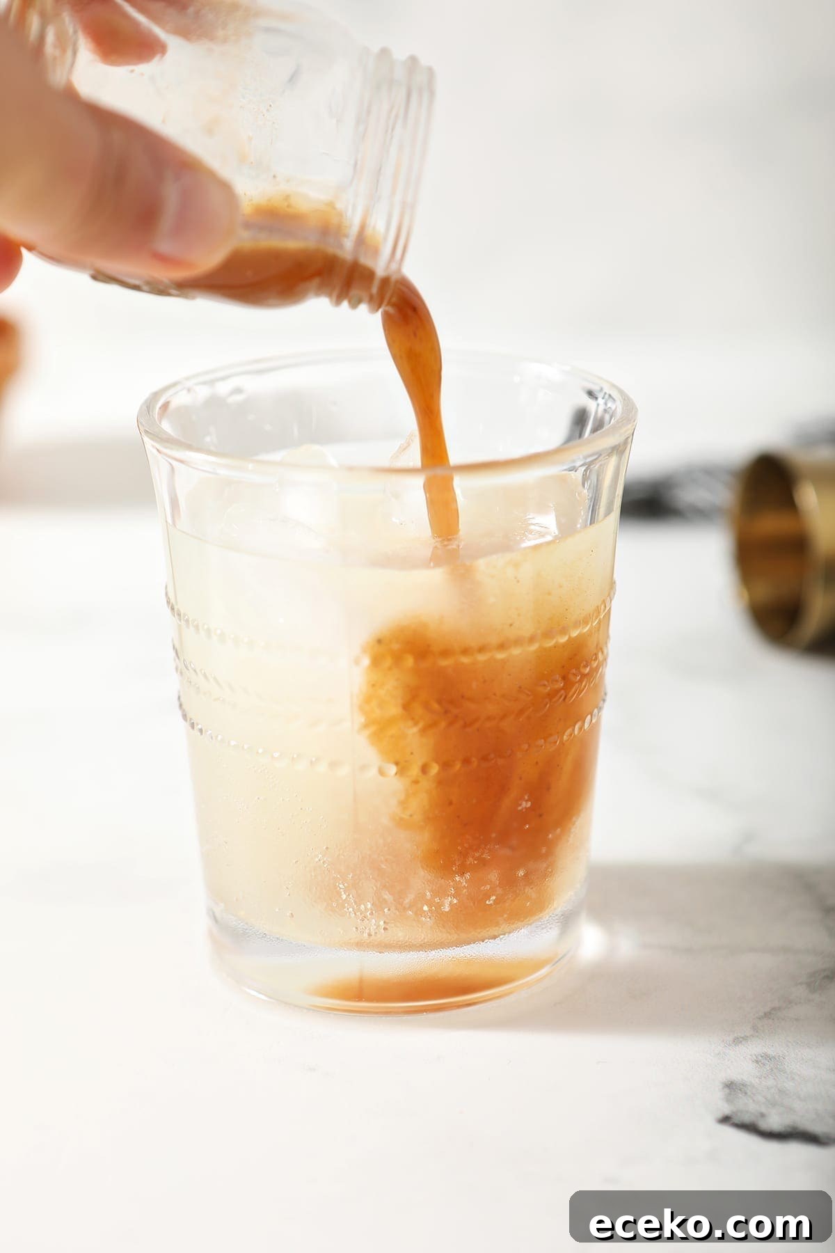 A shot of pumpkin spice syrup is poured into the drink