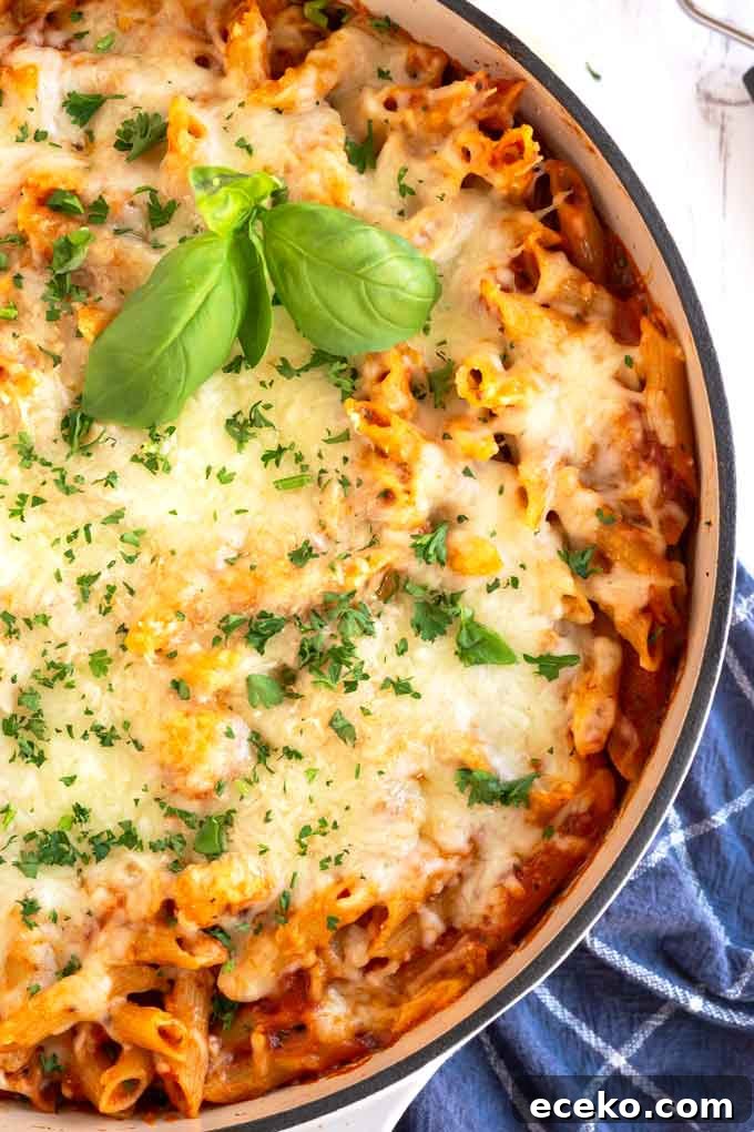 Chicken Parmesan Pasta with Crispy Chicken and Marinara 7 Close up top view of a skillet filled with melted cheese Chicken Parmesan Pasta.