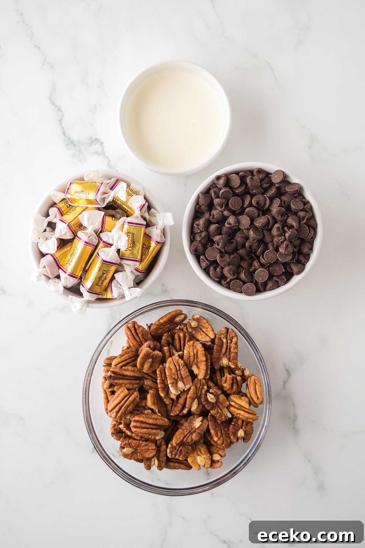 How to Make Classic Homemade Turtle Candies at Home 6 Bowls of caramel candies, chocolate chips, pecans, and a small bowl of cream on a marble countertop are perfect ingredients for crafting delicious homemade turtles.