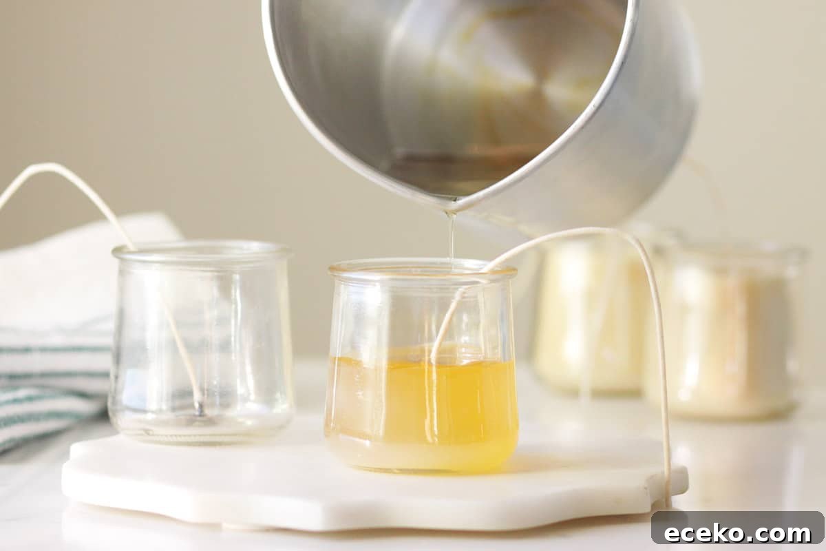 beeswax being poured into a glass jar with a candle wick in it
