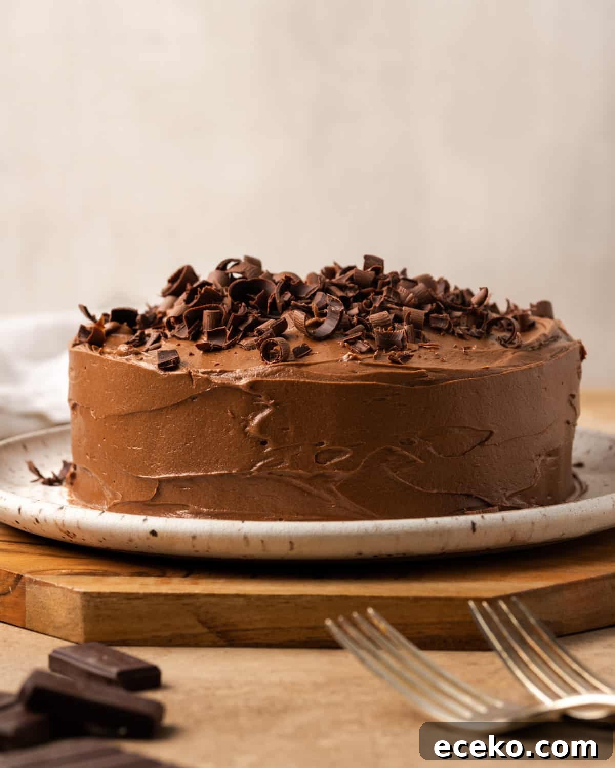 A small chocolate cake covered with chocolate frosting and chocolate curls.