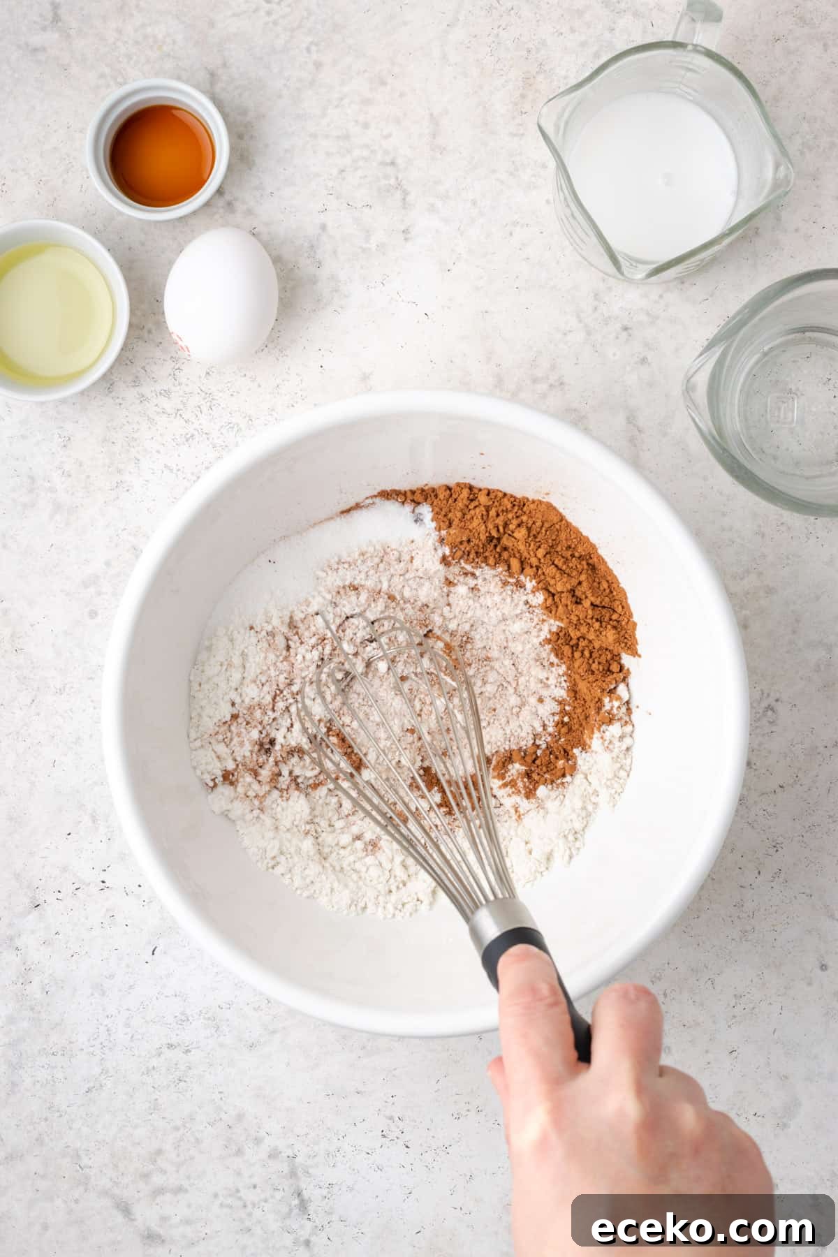 Dry ingredients being whisked together in a large white bowl.