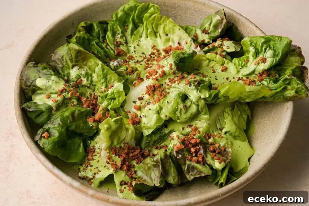 A bowl of green goddess salad sprinkled with breadcrumbs and feta cheese.
