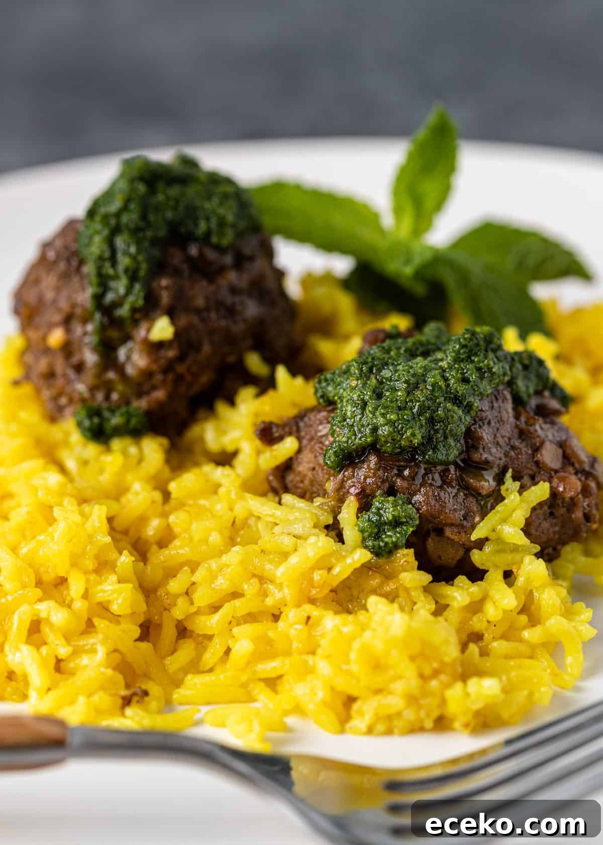 Savory Lamb and Lentil Meatballs with Zesty Lemon Rice 11 closeup side view: two lamb meatballs over lemon rice with mint pesto