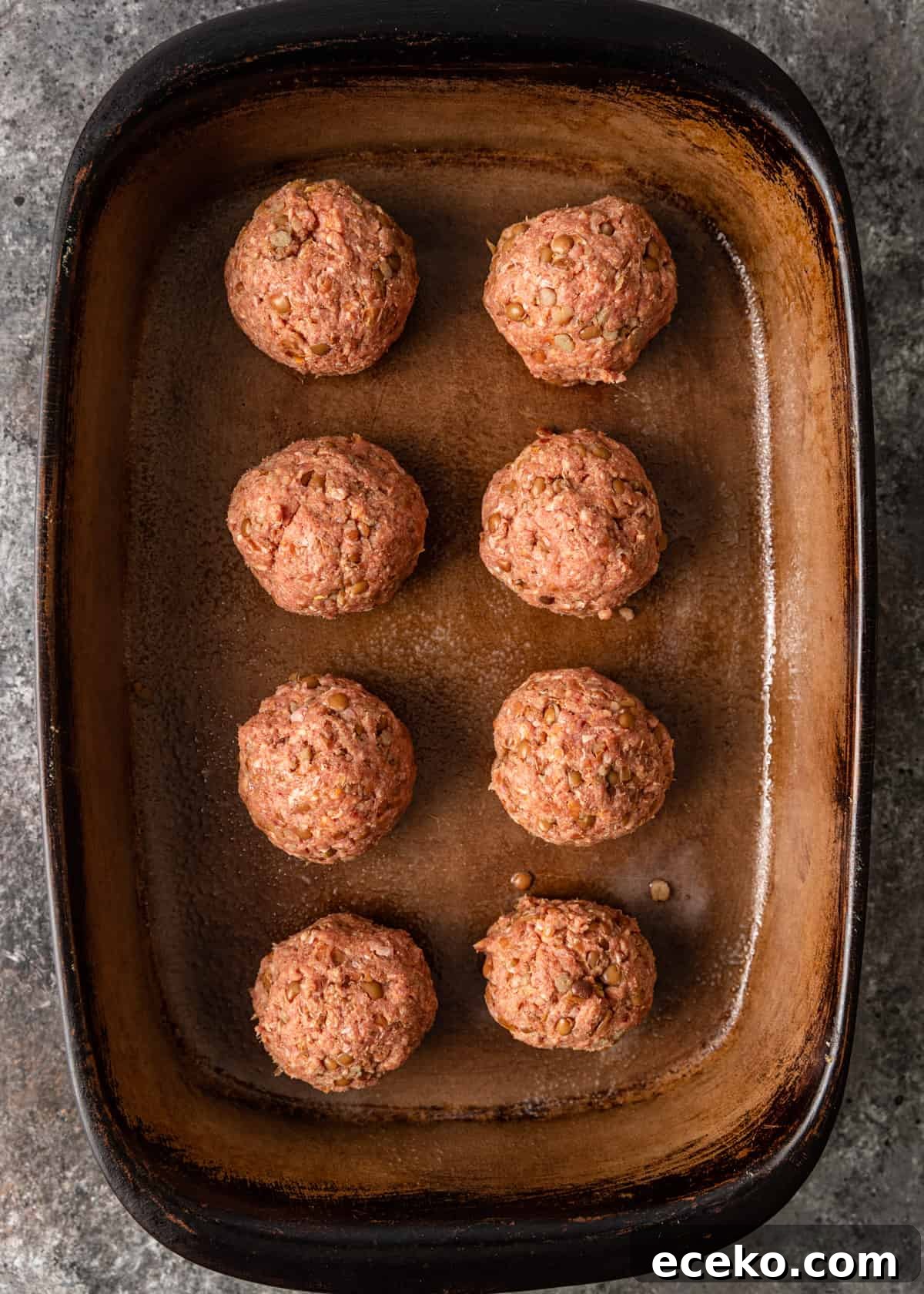 Savory Lamb and Lentil Meatballs with Zesty Lemon Rice 7 overhead process shot: lamb meatballs in a baking dish