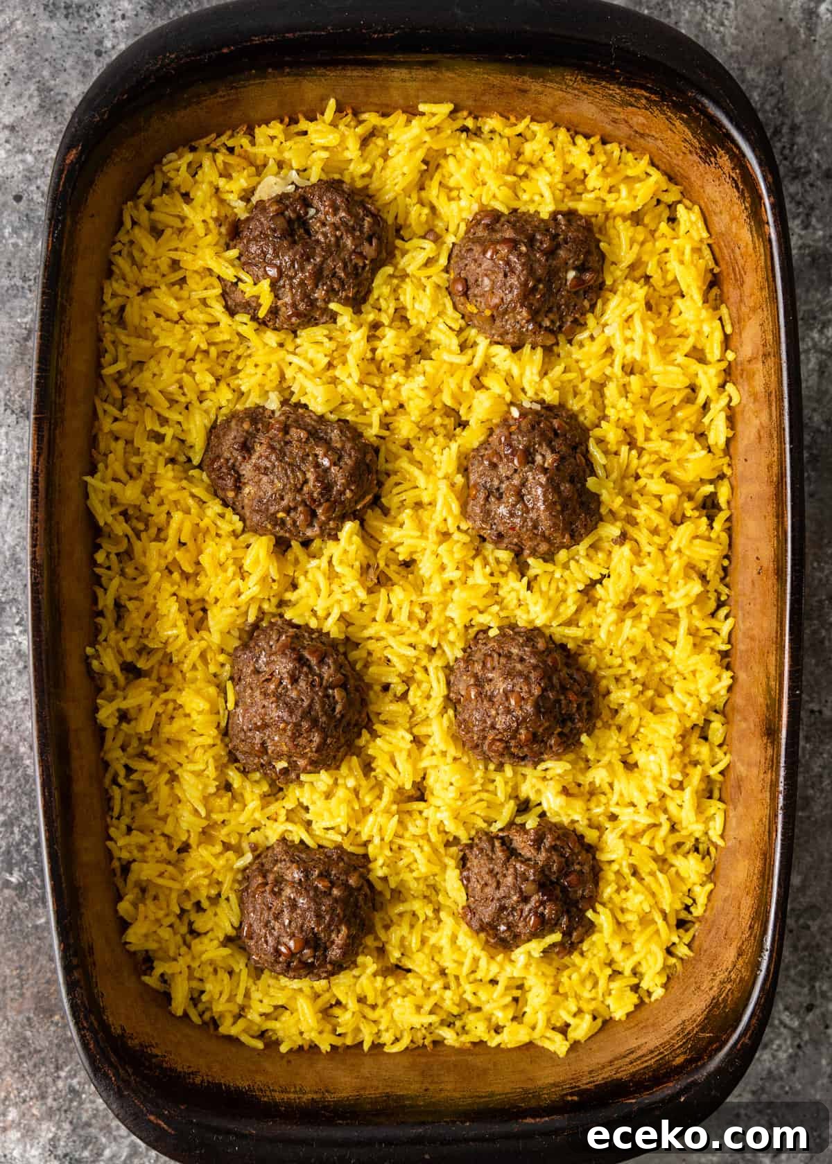 Savory Lamb and Lentil Meatballs with Zesty Lemon Rice 9 overhead process shot: lamb meatballs in a baking dish with lemon rice