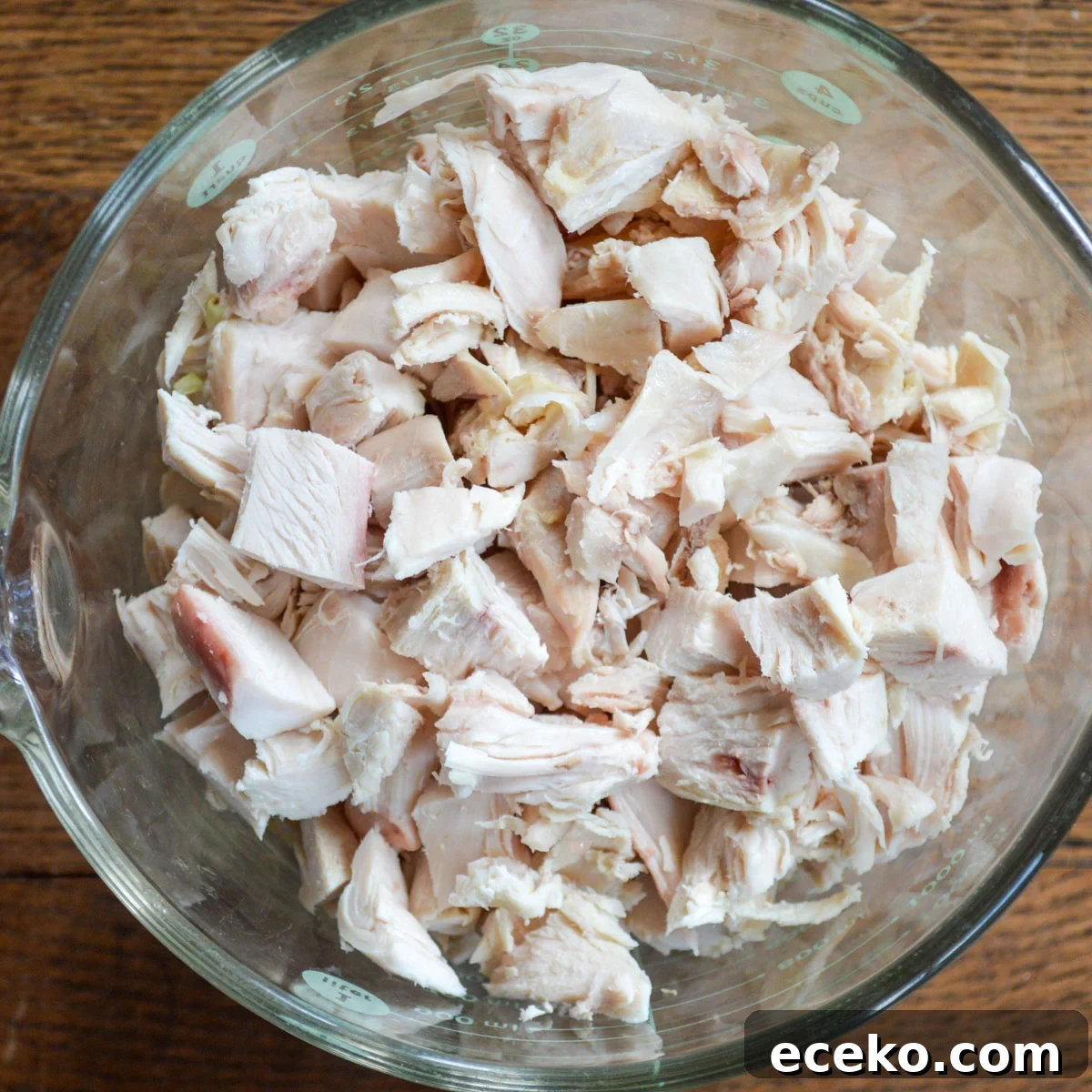 cut up cooked chicken in glass bowl