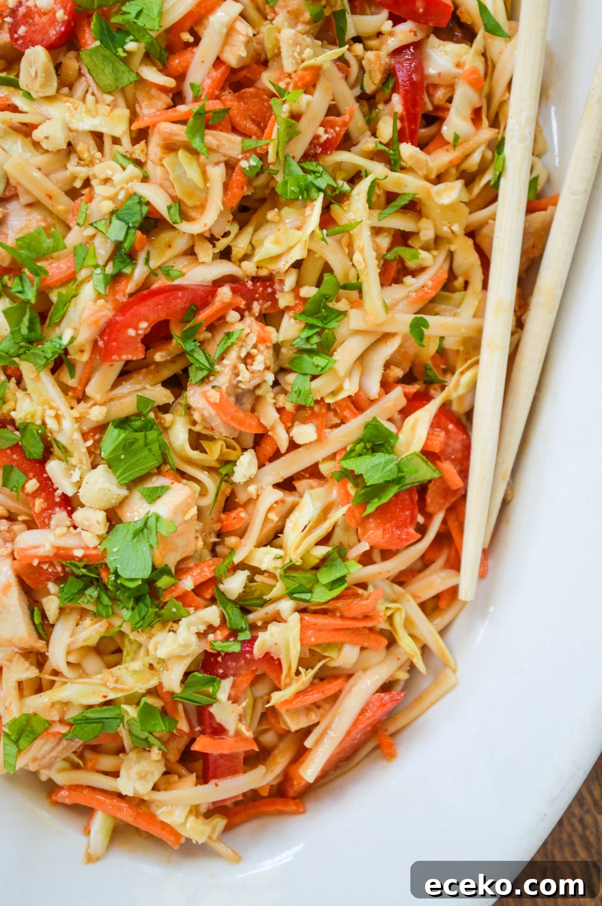 peanut noodles salad on a white platter with chopsticks