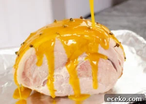 Honey-Glazed Roast Gammon Joint Recipe 9 Pouring honey and mustard glaze over the top of the gammon joint on a baking tray lined with tin foil