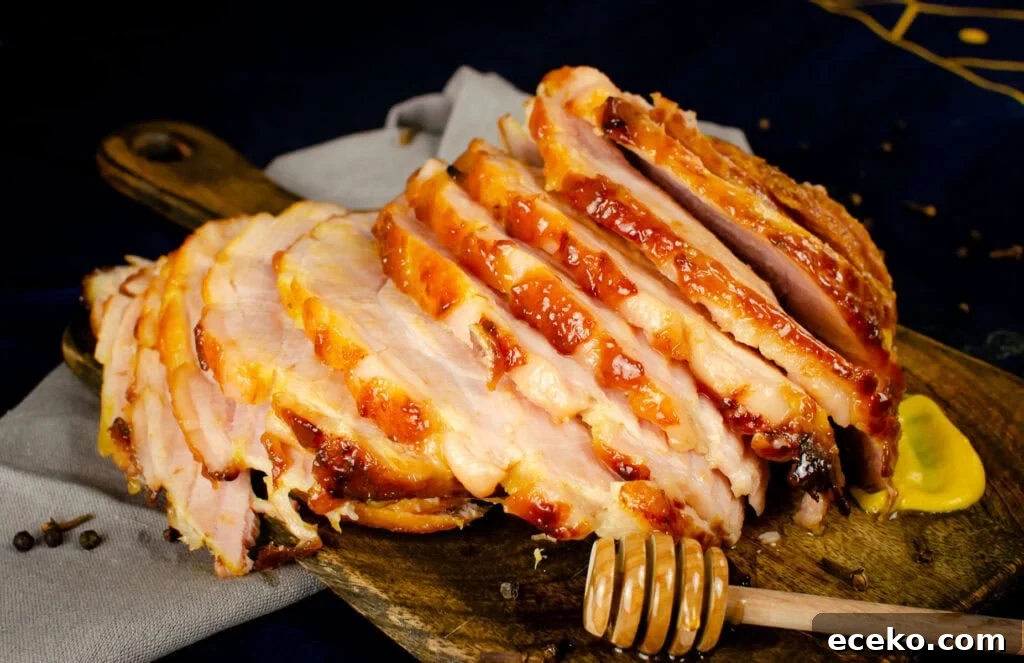 Honey-Glazed Roast Gammon Joint Recipe 27 Slices of honey and mustard glazed honey roast ham on a wooden chopping board with a honey stick coated in honey and a dollop of mustard on the side