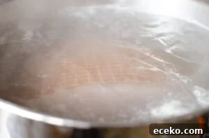 Honey-Glazed Roast Gammon Joint Recipe 5 A gammon joint cooking in a silver pot of boiling water