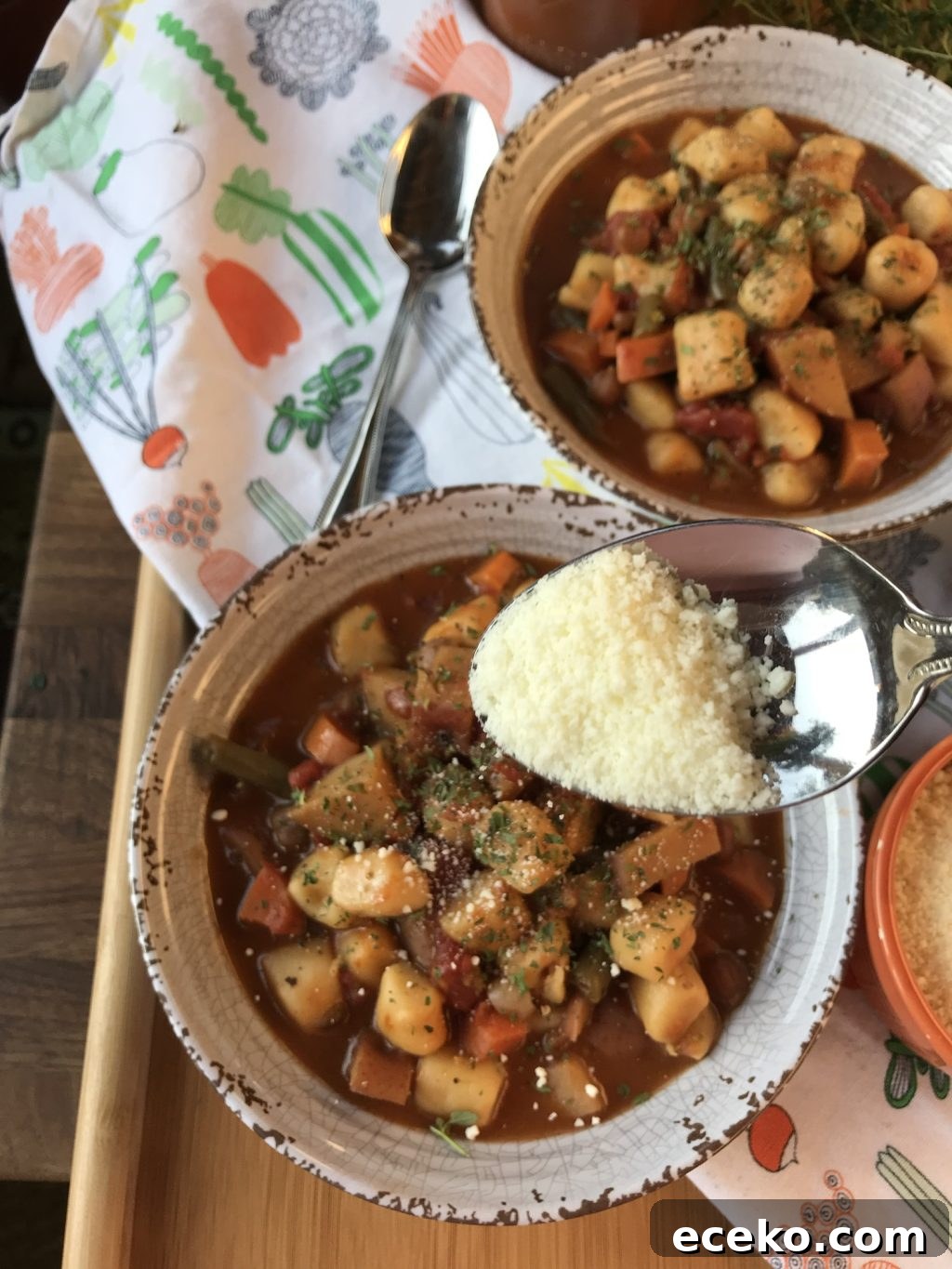 Slow-Cooker Minestrone Soup Recipe for Hearty Weeknight Meals 9 A spoon of parmesan cheese held over a bowl of minestrone soup