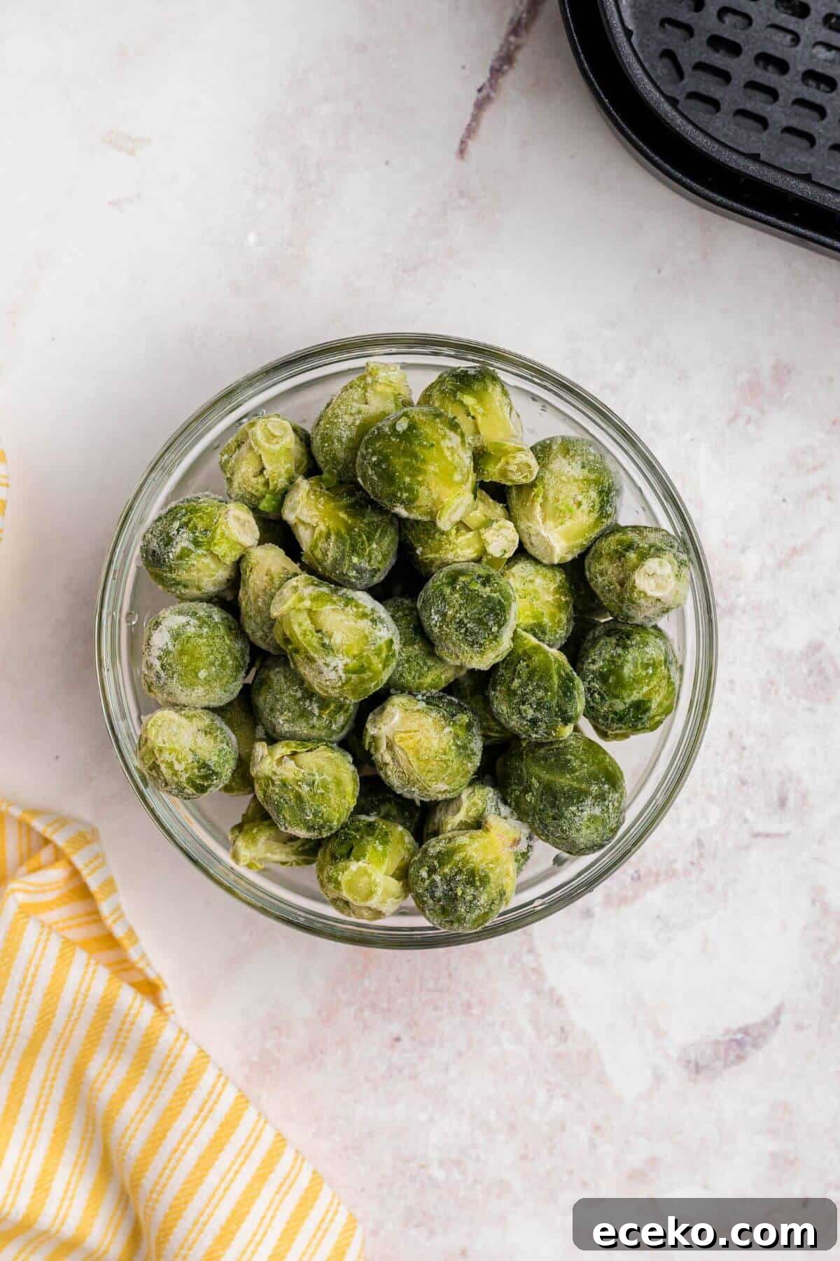 Frozen brussels sprouts in a clear glass bowl. 