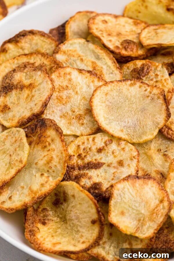 Golden crispy potato chips in a white bowl